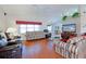 Bright living room with hardwood floors, comfortable seating, and a view into the kitchen at 9688 Sw 45Th Ave, Ocala, FL 34476