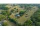 Expansive aerial view of a stunning home on a sprawling, treed and fenced property with lush green pastures at 9748 Sw 74Th Ave, Ocala, FL 34476