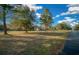 Expansive front yard showcasing a well-maintained lawn and mature trees surrounding a single-story house at 9748 Sw 74Th Ave, Ocala, FL 34476