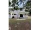 The back of the home has an open patio area, white exterior, and green metal roof at 10245 Sw 105Th St, Ocala, FL 34481