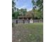 Exterior shot of a wooden barn with a covered area and a dark wood fence at 10245 Sw 105Th St, Ocala, FL 34481