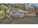 Exterior view of a weathered barn with a metal roof and siding, nestled among mature trees at 10245 Sw 105Th St, Ocala, FL 34481