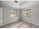 Bright bedroom featuring wood-look flooring and two windows, offering ample natural light at 10245 Sw 105Th St, Ocala, FL 34481