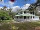 Two-story home with a green metal roof, a white exterior, and a wrap around porch at 10245 Sw 105Th St, Ocala, FL 34481