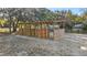 Outdoor horse shelter with wooden stalls in a sandy paddock at 10245 Sw 105Th St, Ocala, FL 34481