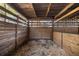 Enclosed wooden horse stall with wood chip bedding and metal bar divider at 10245 Sw 105Th St, Ocala, FL 34481