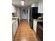 Classic kitchen featuring white cabinets, terracotta tiled floors, and stainless steel appliances at 10245 Sw 105Th St, Ocala, FL 34481