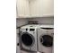 Bright laundry room featuring washer, dryer, and overhead cabinets at 10245 Sw 105Th St, Ocala, FL 34481