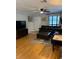 Living room featuring a leather sofa, TV, hardwood flooring, and ceiling fan at 10245 Sw 105Th St, Ocala, FL 34481