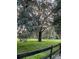 Lush pasture with mature oak tree and a sturdy wooden fence at 10245 Sw 105Th St, Ocala, FL 34481