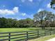 Idyllic horse property featuring verdant pastures, perimeter fence, and mature trees at 10245 Sw 105Th St, Ocala, FL 34481