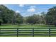 Beautiful fenced pasture under a blue sky with scattered clouds and mature trees at 10245 Sw 105Th St, Ocala, FL 34481