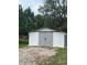 Exterior of a white shed with gray doors and gravel driveway at 10245 Sw 105Th St, Ocala, FL 34481