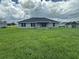 Expansive backyard with lush lawn and modern home featuring large windows and a sleek roofline at 10927 Sw 41St Ave, Ocala, FL 34476