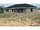 The back exterior of the single-story home shows a door to the porch, with an unfinished yard, and plenty of natural light at 10927 Sw 41St Ave, Ocala, FL 34476
