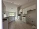 Bright kitchen featuring tile flooring, white cabinets, and an open view into the living area at 10927 Sw 41St Ave, Ocala, FL 34476