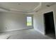 Main bedroom with tray ceiling, large window for natural light, and ensuite bathroom entrance at 10927 Sw 41St Ave, Ocala, FL 34476