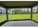 Covered patio offers a serene view of the expansive green lawn and surrounding wooded area at 10927 Sw 41St Ave, Ocala, FL 34476