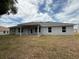 The rear exterior shows a covered patio and a spacious lawn and yard at 13 Nw 45Th Loop, Ocala, FL 34475