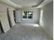 Spacious bedroom featuring tray ceilings, a large window, and prepped for finishing at 13 Nw 45Th Loop, Ocala, FL 34475