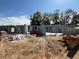 A construction site featuring a concrete foundation and wall framing for a new home under a sunny, partly cloudy sky at 13 Nw 45Th Loop, Ocala, FL 34475