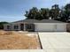 New home with a wide driveway leading to a two-car garage and a lawn ready for landscaping at 13 Nw 45Th Loop, Ocala, FL 34475