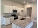 Well-lit kitchen featuring stainless steel appliances, granite countertops, and white cabinetry at 13 Nw 45Th Loop, Ocala, FL 34475
