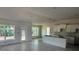 Open-concept living space with modern tile floors, large windows and an unfinished kitchen area at 13 Nw 45Th Loop, Ocala, FL 34475