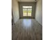 Bright living room with wood-look tile flooring and a large window with lots of natural light at 13 Nw 45Th Loop, Ocala, FL 34475