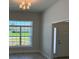 Bright living room with a chandelier and a large window offering an outside view of the neighborhood at 13 Nw 45Th Loop, Ocala, FL 34475