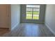 Living room showcasing wood-look tile flooring and a large window with backyard views at 13 Nw 45Th Loop, Ocala, FL 34475