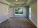 Spacious primary bedroom with tray ceiling and large windows providing natural light at 13 Nw 45Th Loop, Ocala, FL 34475