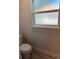 Bathroom featuring a white toilet and obscured glass window for natural light and privacy at 13 Nw 45Th Loop, Ocala, FL 34475