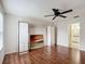 Bedroom with wood floors and built-in mirrored wardrobe at 1509 Hollyberry Pl, The Villages, FL 32162