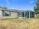 Rear exterior view showing house with screened porch at 1509 Hollyberry Pl, The Villages, FL 32162