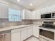 White kitchen cabinets, stainless steel appliances, and a double sink at 1509 Hollyberry Pl, The Villages, FL 32162