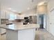 Modern kitchen with island, stainless steel appliances, and white cabinets at 1509 Hollyberry Pl, The Villages, FL 32162