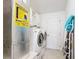 Bright laundry room with washer, dryer, and storage cabinets at 1509 Hollyberry Pl, The Villages, FL 32162