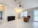 Bright living room with tile floor, large window, and ceiling fan at 1509 Hollyberry Pl, The Villages, FL 32162