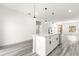 White kitchen with island and pendant lighting, gray flooring at 15413 Sw 65Th Terrace Rd, Ocala, FL 34473