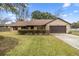 House exterior featuring a brown roof, stone accents, and a two-car garage at 2540 Se 35Th St, Ocala, FL 34471