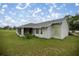 Back exterior view of single story home with screened lanai and green lawn at 331 Oak Lane Dr, Ocala, FL 34472