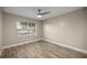 Bedroom with a ceiling fan, wood look tile floors and large window at 331 Oak Lane Dr, Ocala, FL 34472