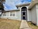 Charming home exterior featuring a screened front door and manicured landscaping at 331 Oak Lane Dr, Ocala, FL 34472