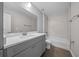 Bathroom with gray vanity, white bathtub, and marble-look walls at 3444 Se 139 Ln, Summerfield, FL 34491