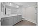 Double vanity bathroom with gray cabinets and a walk-in shower at 3444 Se 139 Ln, Summerfield, FL 34491