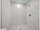 Modern shower with marble-style tile and hexagonal floor tile at 3444 Se 139 Ln, Summerfield, FL 34491