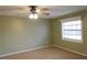 Bedroom with carpet flooring, neutral walls, a ceiling fan and a window at 404 Cr 487, Lake Panasoffkee, FL 33538