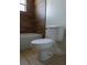 A bathroom features a toilet and tiled shower and walls at 404 Cr 487, Lake Panasoffkee, FL 33538