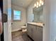 Clean bathroom with wood-look flooring, gray vanity, and a well-lit mirror at 4373 Sw 90Th Pl, Ocala, FL 34476